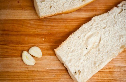 Натираем чесноком кусочки хлеба