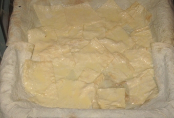 выкладываем первый слой - кусочки лаваша, смоченные яично-кефирной смесью
