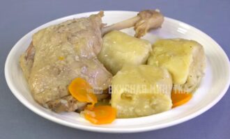 Утка тушеная с овощами с луковыми рулетиками.